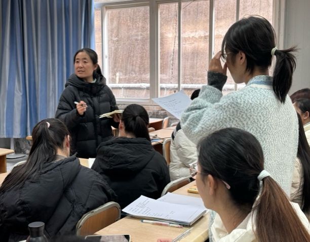 一群人看著桌子上的女人描述已自動(dòng)生成